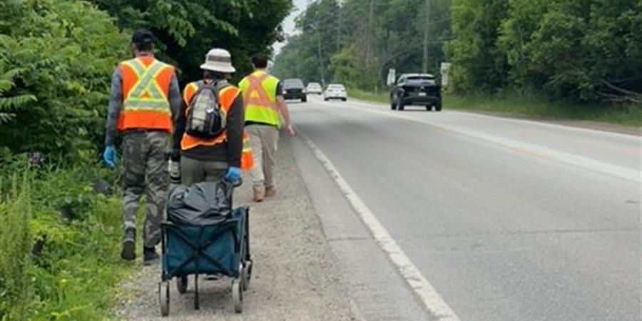 An image showing a group of people walking at the side of a road